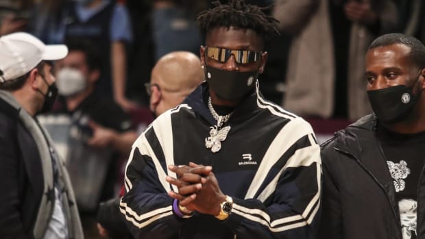 Antonio Brown looks on from the sidelines while watching Grizzlies-Nets basketball game.